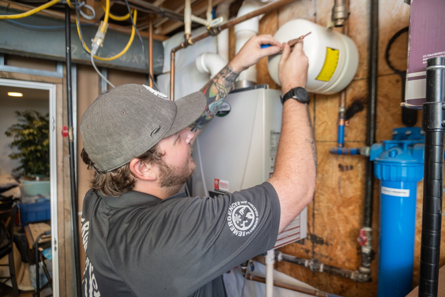 A technician works on a hot water system; part of Emergency Plumbing's HVAC service