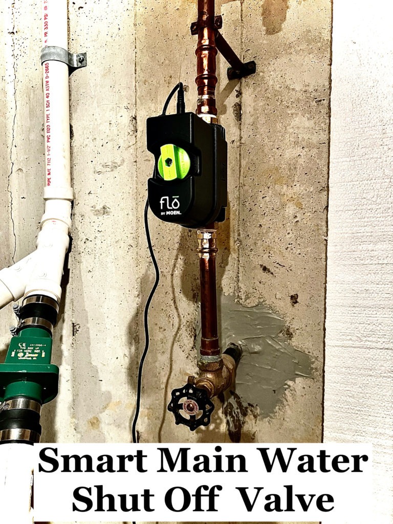 Smart main water shut off valve is mounted on pipes against a basement wall.