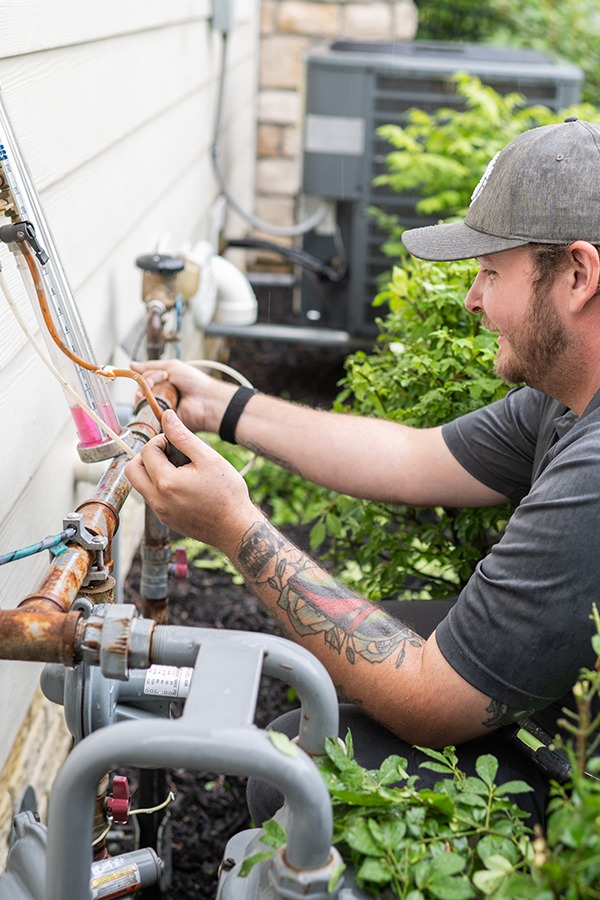 A technician repairs gas lines at a residence to ensure their integrity.