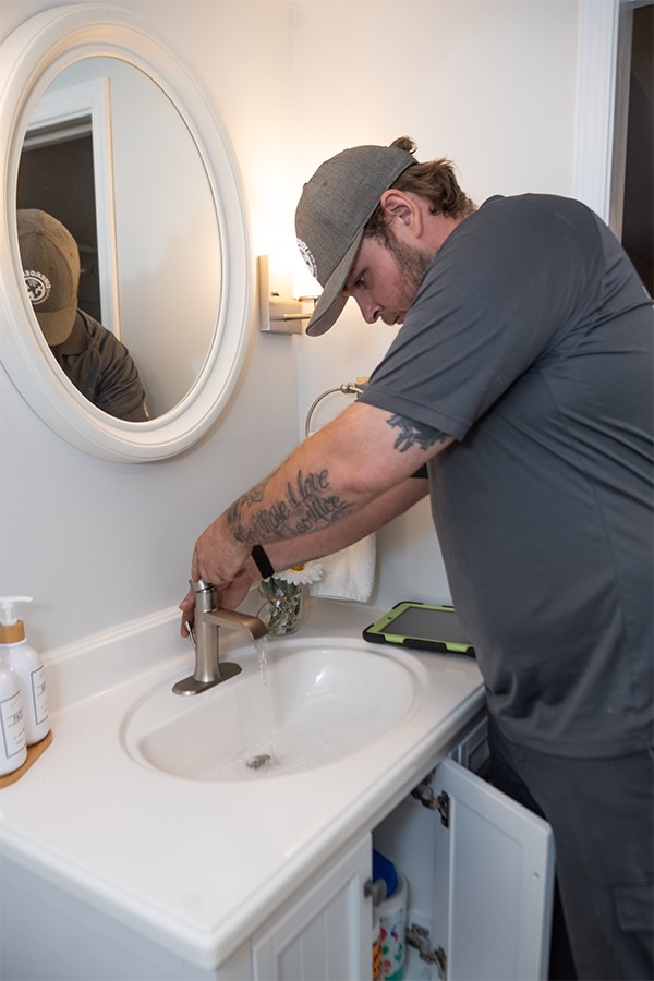 A plumber is shown fixing a faucet, possibly indicating leak repair services.