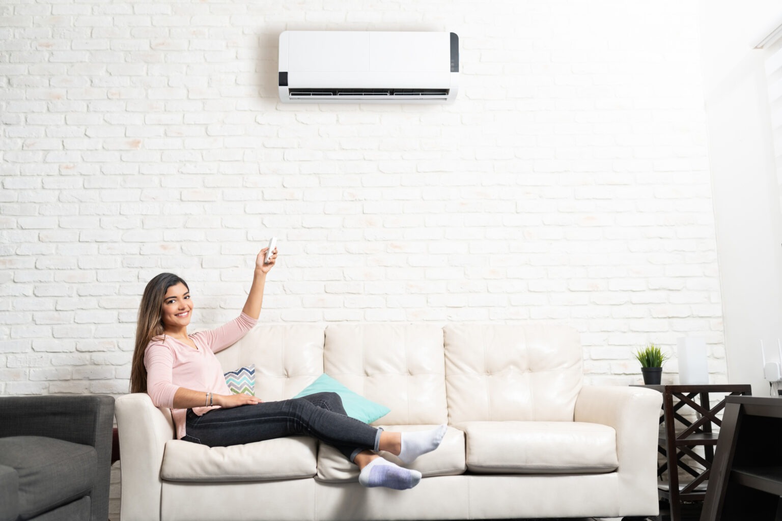 Smiling woman relaxing in her cooled home. 