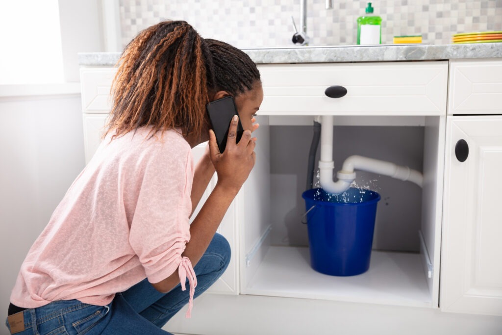 A worried woman calls about a leaky pipe under her sink.